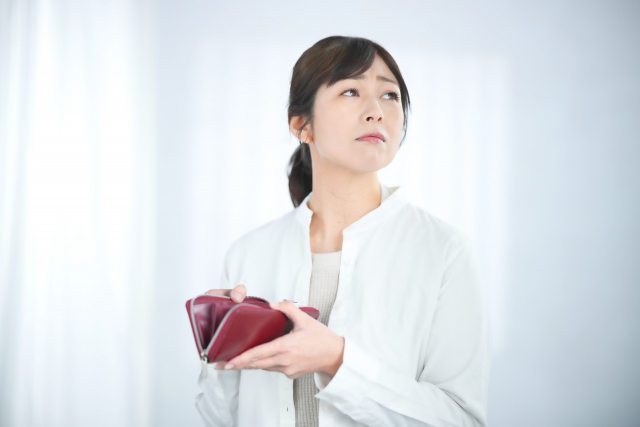 財布を開けて困った顔をする女性